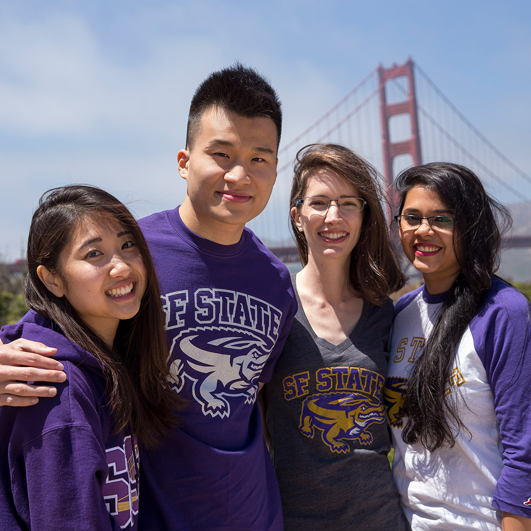 Four students wearing SFSU shirts in front of the Golden Gate Bridge