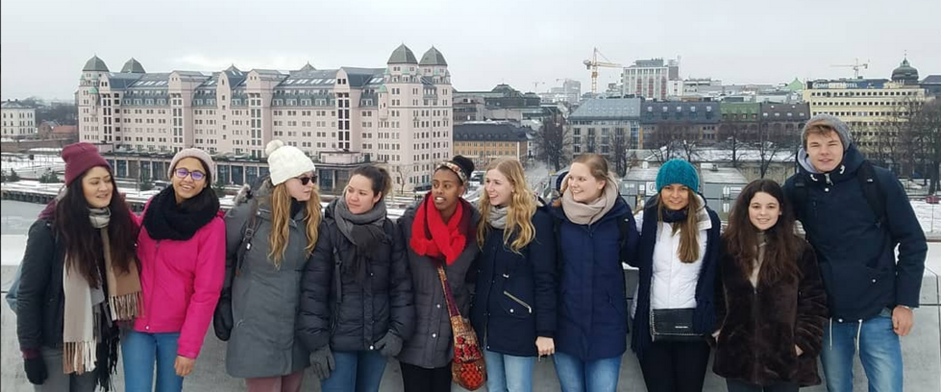 Large group of friends in Norway during winter on a bridge