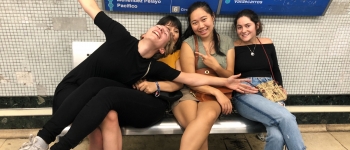 Four girls on a bench at a train station 