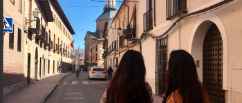 Two girls walking down a narrow street in Spain